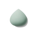 Sage green teardrop-shaped All Covered Shapable Makeup Sponge with fine porous texture on white background.