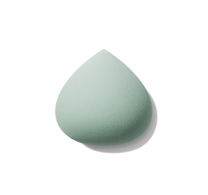 Sage green teardrop-shaped All Covered Shapable Makeup Sponge with fine porous texture on white background.