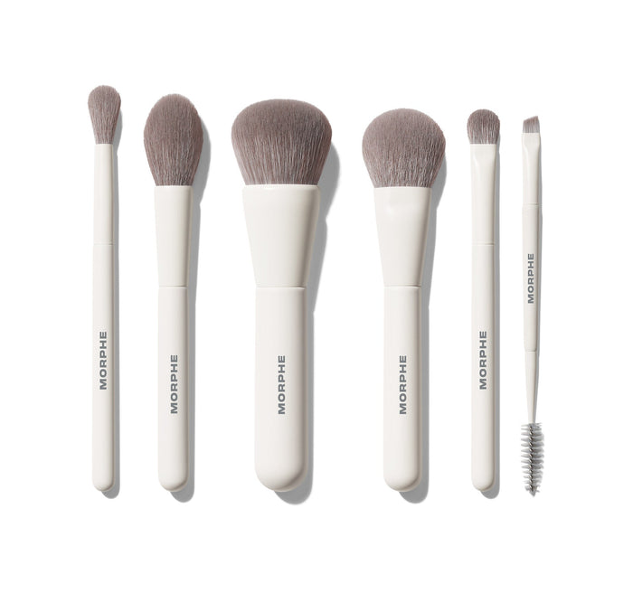 Along For The Glide 6 Piece Travel Brush Set featuring six white-handled MORPHE brushes with grey bristles laid flat, including eye, cheek, and dual-ended brow/liner tools.