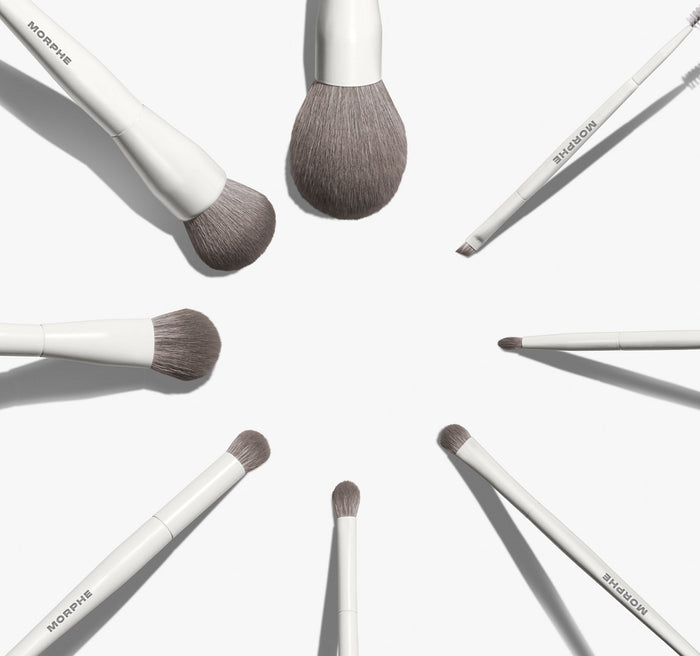 Morphe Best Of Blends 8 Piece Face Eye Brush Set with white handles and gray bristles arranged in a starburst circle, MORPHE printed on each handle.
