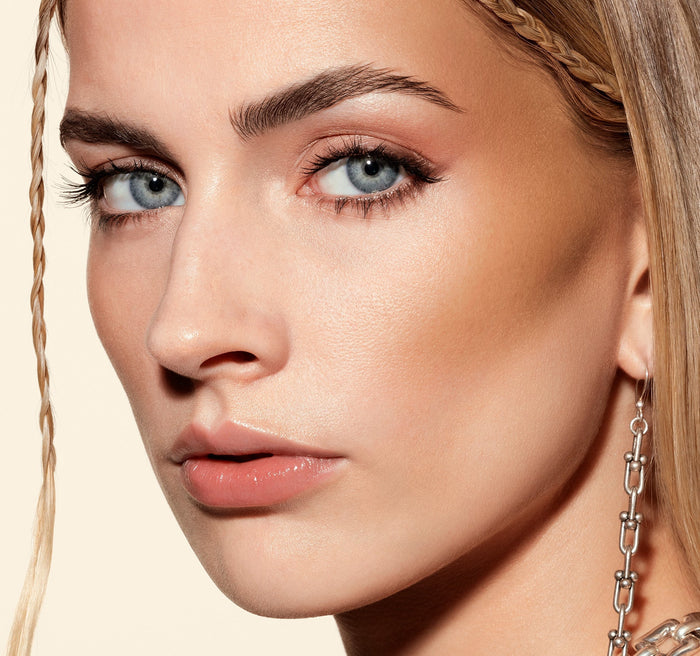 {Money Honey} Model wearing Hot Shot Sun Drops in Money Honey, showcasing a warm peachy-gold shimmer on lids with a glowing, sun-kissed complexion.