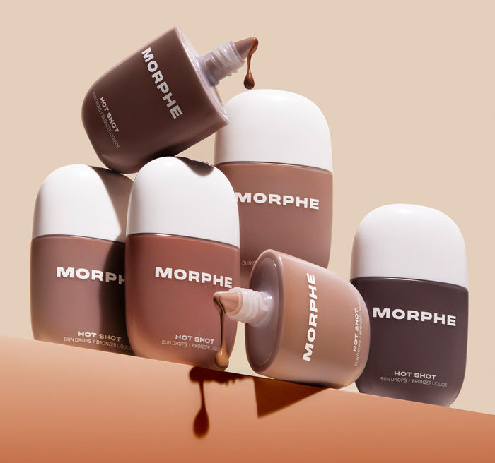 {Money Honey} Group of Morphe Hot Shot Sun Drops / Bronzer Liquide bottles in varied bronzer shades stacked with droppers open and liquid drips spilling out.
