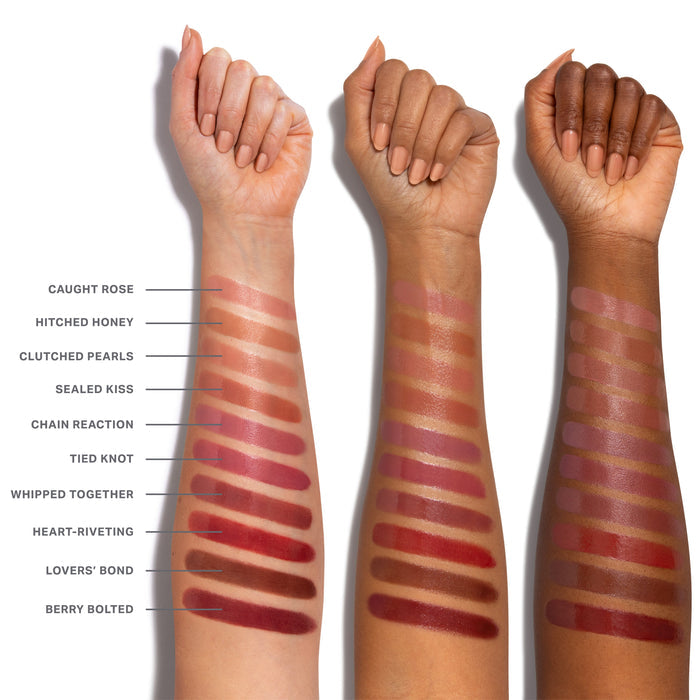 Liplock Glossy Lipstick arm swatches across three skin tones showing shades Caught Rose, Hitched Honey, Clutched Pearls, Sealed Kiss, Chain Reaction, Tied Knot, Whipped Together, Heart-Riveting, Lovers' Bond, and Berry Bolted.