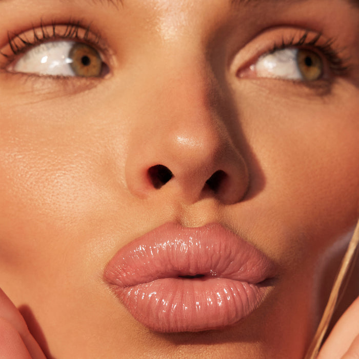 {Caught Rose} Liplock Glossy Lipstick campaign close-up showing full, glossy rose-pink lips on a model with glowing skin.