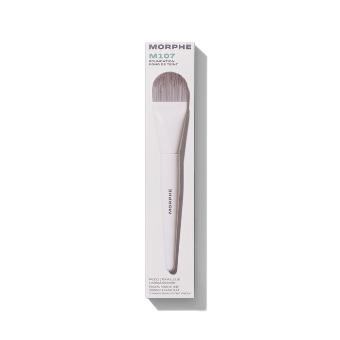 Morphe M107 Paddle Cream & Liquid Foundation Brush in white box labeled "MORPHE M107 FOUNDATION FOND DE TEINT PADDLE CREAM & LIQUID FOUNDATION BRUSH PINCEAU FOND DE TEINT CRÈME ET LIQUIDE PLAT CONTAINS 1 BRUSH / CONTIENT 1 PINCEAU."