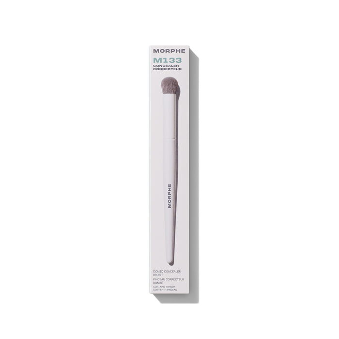 Morphe M133 Domed Concealer Brush in white box labeled "MORPHE M133 CONCEALER CORRECTEUR DOMED CONCEALER BRUSH PINCEAU CORRECTEUR BOMBÉ CONTAINS 1 BRUSH CONTIENT 1 PINCEAU," lavender handle with taupe bristles.