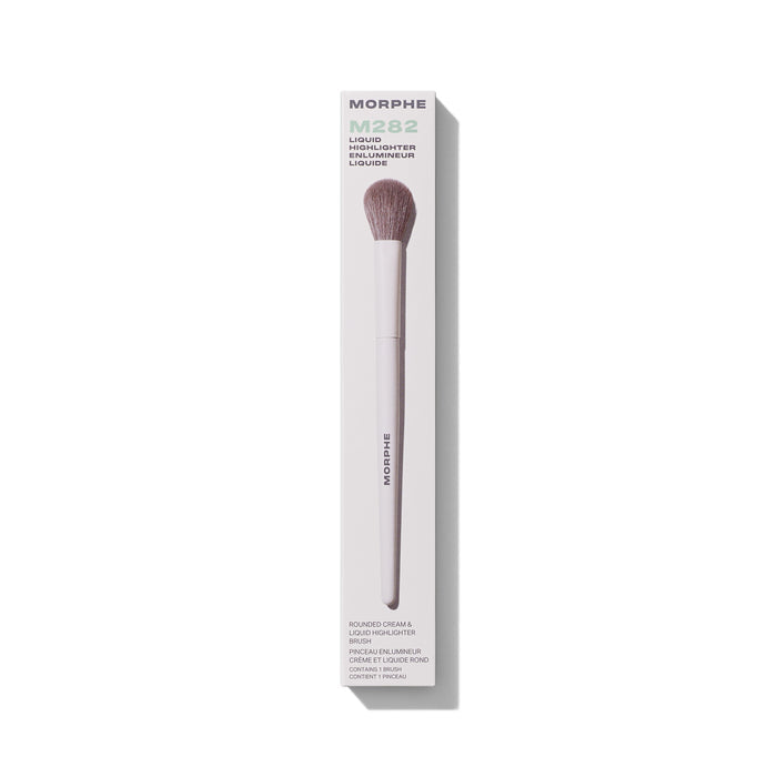 Morphe M282 Rounded Cream & Liquid Highlighter Brush in packaging labeled "MORPHE M282 LIQUID HIGHLIGHTER ENLUMINEUR LIQUIDE ROUNDED CREAM & LIQUID HIGHLIGHTER BRUSH CONTAINS 1 BRUSH" with taupe dome bristles and white handle.