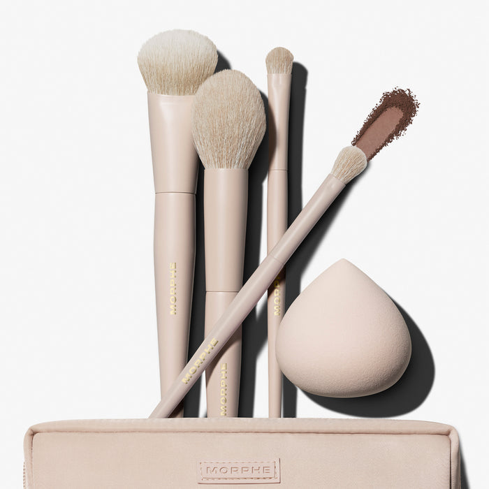 Morphe Iced Oat Latte Custom Blends 5-Piece Brush Set fanned out of beige makeup bag with eyeshadow swatch and beauty sponge