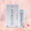 The image shows a box and a container of Glutone 1000 tablets, with a single tablet displayed in front. The background is plain and pink-toned.